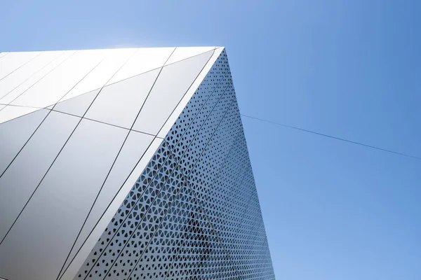 Edificio con facciata in alluminio bianco e pannelli in alluminio contro il cielo blu . — Foto Stock