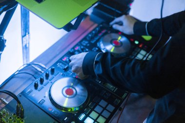 DJ çalış ve mix müzik dijital mikser denetleyicisinde. Yakın çekim Dj performans denetleyicisi, dijital MIDI pikap sistemi, ayarlanabilir tork, alüminyum-döner tabağı, ses geçişi ayar düğmesi, topuzu ve kaymak, düğme.