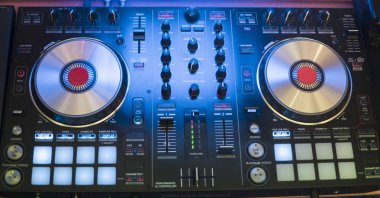 DJ çalış ve mix müzik dijital mikser denetleyicisinde. Yakın çekim Dj performans denetleyicisi, dijital MIDI pikap sistemi, ayarlanabilir tork, alüminyum-döner tabağı, ses geçişi ayar düğmesi, topuzu ve kaymak, düğme.