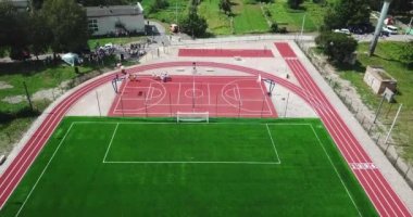 Boş spor Bahçesi stadyum kuş bakışı görünüme üzerinden. Kırmızı spor büyük tenis ve basketbol oynamak için zemin. Futbol futbol sahası yeşil ve yollar çalıştıran