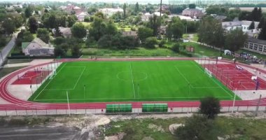 Boş spor bahçesi kuş bakışı görünüme köyden stadyumda. Kırmızı spor büyük tenis ve basketbol oynamak için zemin. Futbol futbol sahası yeşil ve yollar çalıştıran.