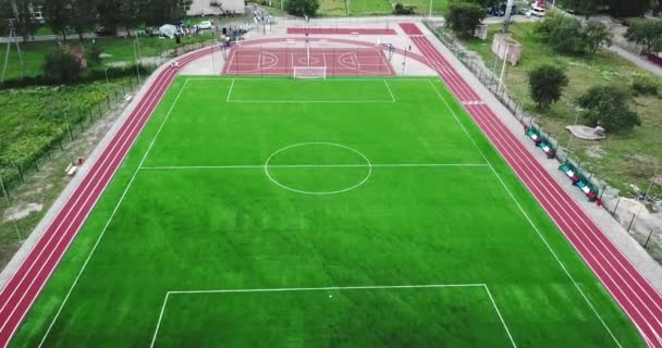 Stade de jeux vide avec terrain de sport rouge pour jouer au grand basket-ball de tennis et au terrain de football vert et pistes de course . — Video