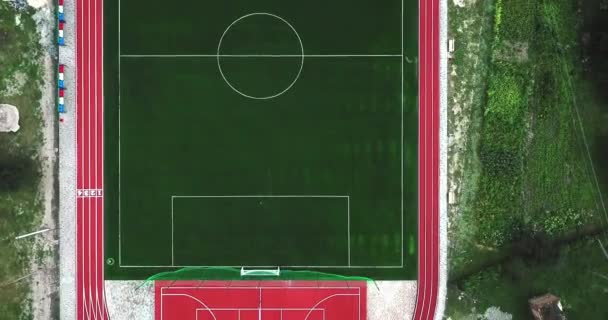 Stade de jeux de sport vide de vue des oiseaux. Terrain de sport rouge pour jouer au grand tennis et au basket. Terrain de football vert et routes de course . — Video