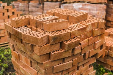 İnşaat için kırmızı tuğla yığını. Ortak kalite bina tuğla hazır kullanım için yığılmış.