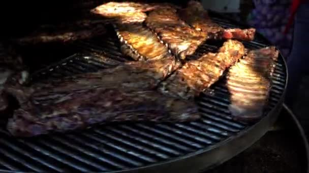 Costelas de lado de porco cozinhando em um grande churrasco ao ar livre em um festival de comida . — Vídeo de Stock