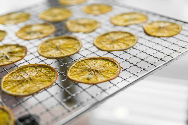 Candied orange slices on grid for drying. Dried fruits which can be used as a decoration to the meal or cocktails. Healthy vegetarian food rich on a vitamins and microelements.