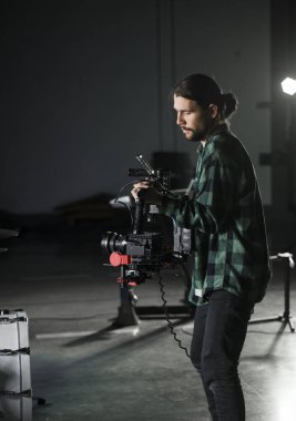 Professional videographer holding camera on 3-axis gimbal. Videographer using steadicam. Pro equipment helps to make high quality video without shaking. clipart