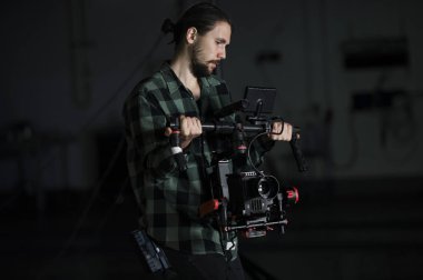 Profesyonel kameramanların kamera 3 eksenli gimbal üzerinde tutarak. Kameramanların Steadicam kullanarak. Pro ekipmanları sallayarak olmadan yüksek kaliteli video yapmak için yardımcı olur.