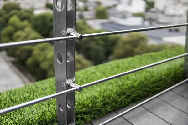 Details of fence made of stainless steel profile with an artificial raffa on the background. — Stock Photo, Image