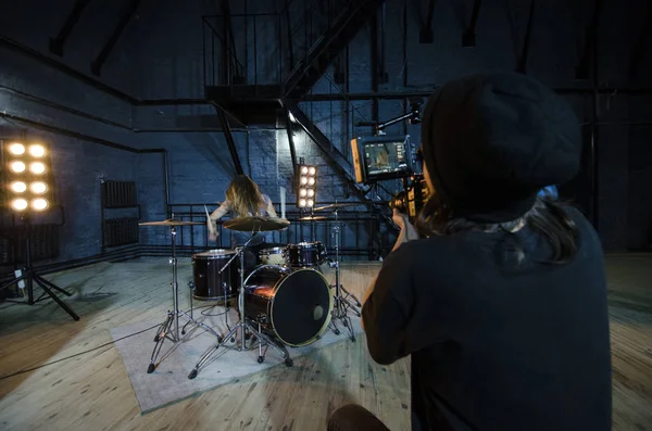 Professioneller Videofilmer mit digitaler Videokamera für das Filmen eines Schlagzeugers für ein Musikvideo. — Stockfoto