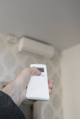 El kremi duvardaki Tarih Yönetmen: uzaktan kumanda ile. Uzaktan kumanda açık Klima için 25 santigrat derece onun yatak odasında soğutmalı kullanarak ele mans.