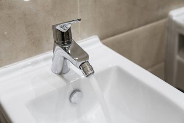 Modern banyo içinde akan bir su ile beyaz seramik bide ayrıntılarını.