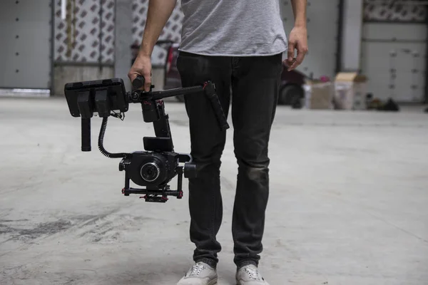 Vidéographe professionnel tenant la caméra sur cardan 3 axes. Vidéaste utilisant le stéadicam. L'équipement Pro aide à faire des vidéos de haute qualité sans trembler . — Photo