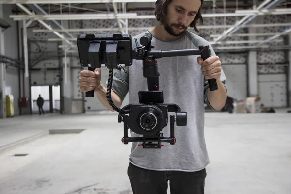 Vídeo profissional segurando câmera no gimbal de 3 eixos. Videógrafo a usar steadicam. Pro equipamento ajuda a fazer vídeo de alta qualidade sem agitar . — Fotografia de Stock