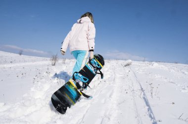 Kız snowboard snowboard yaparken beyaz kar ile.