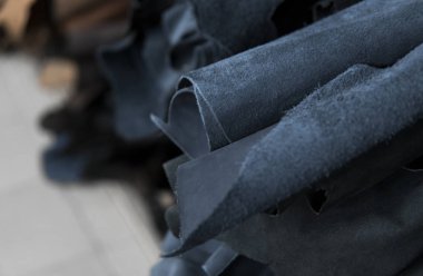 Bir rulo deri çeşitli bölümlerine. Renkli deri parçaları. Mavi ve siyah deri ve rulo. Çanta, Ayakkabı, giyim ve aksesuar üretimi için hammadde.