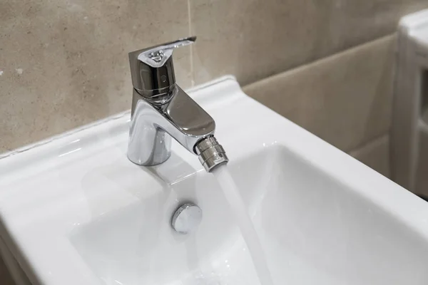 Detaljer för vita keramiska bidé med en rinnande vatten i modernt badrum. — Stockfoto