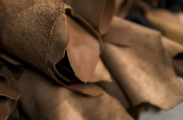 Beda potongan kulit dalam gulungan. Potongan-potongan kulit berwarna. Rolls dari kulit merah coklat alami. Bahan baku untuk pembuatan tas, sepatu, pakaian dan aksesoris . — Stok Foto