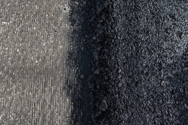 Freshly laid black bitumen asphalt with a high edge to the gravel showing the structure. Laying a new asphalt on the roads. Construction of the road. — Stock Photo, Image