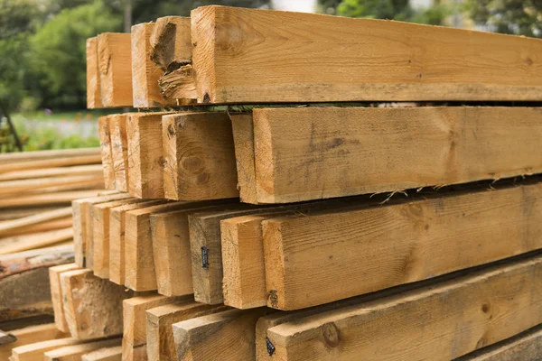 Деревянные панели хранятся вне промышленного склада на металлических стеллажах для использования в строительстве и строительстве . — стоковое фото