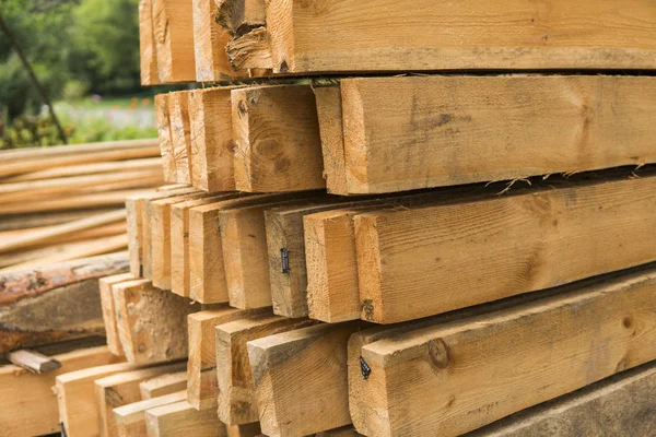 Panneaux en bois stockés à l'extérieur d'un entrepôt industriel sur des étagères métalliques pour la construction et la construction . — Photo