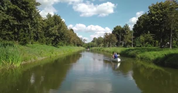 Dva lidé na lodi plovoucí na řece. — Stock video