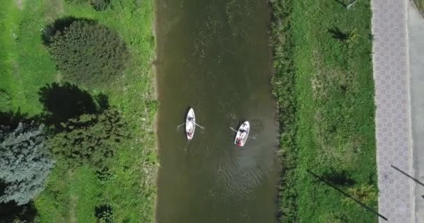 Deux personnes sur un bateau flottant sur la rivière . — Video