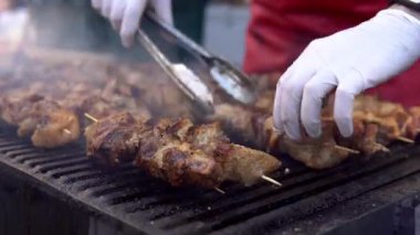 Yaz açık hava partisinde arkadaşları için barbekü ızgara üzerinde et pişirme Adam. Sıcak kömürde domuz eti pişirmek. Geleneksel piknik yemeğinin yakın çekim. Odun kömürü üzerinde ızgara et.