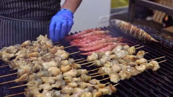 여름 야외 파티에서 친구들을 위해 바베큐 그릴에서 바다 음식을 요리하는 남자. 뜨거운 숯에 바다 음식을 요리. — 비디오