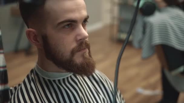 Close-up op de mens hairstyling en haircutting in een kapper of kapsalon met behulp van schaar en haardroger. Het haar verzorgen. Barbershop. — Stockvideo