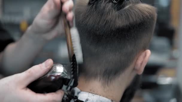 Närbild på hanar hårstyling i frisörsalong med professionella trimmer. Mans klippning på frisörsalong med elektrisk klippare. Grooming hår. — Stockvideo