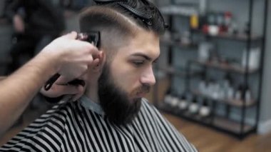 Erkek saç şekillendirme ile profesyonel düzeltici bir kuaför dükkanında yakından görmek. Kuaför Salonu Elektrik kesme makinesi ile kanununu mans. Saç bakım.