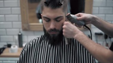 Erkek saç şekillendirme ile profesyonel düzeltici bir kuaför dükkanında yakından görmek. Kuaför Salonu Elektrik kesme makinesi ile kanununu mans. Saç bakım.