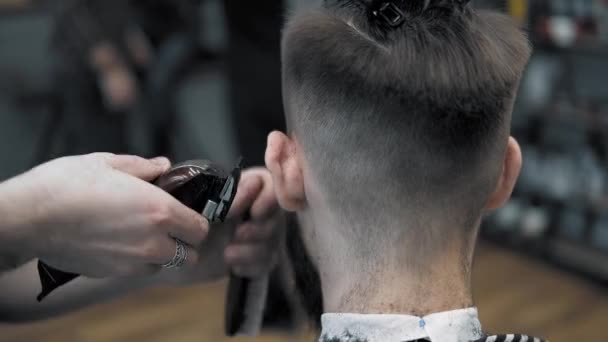 Крупный план на мужскую прическу в парикмахерской с профессиональной триммером. Ман стрижка в парикмахерской с электрическим клиппером. Груминг волос . — стоковое видео