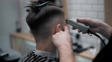 Erkek saç şekillendirme ile profesyonel düzeltici bir kuaför dükkanında yakından görmek. Kuaför Salonu Elektrik kesme makinesi ile kanununu mans. Saç bakım.