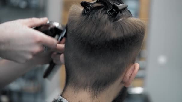 Vergrote weergave op mannetjes hairstyling in een kapper met professionele trimmer. Mans haircutting in kapsalon met elektrische clipper. Het verzorgen van het haar. — Stockvideo