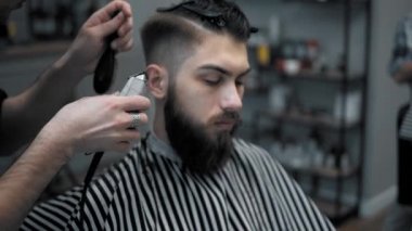 Erkek saç şekillendirme ile profesyonel düzeltici bir kuaför dükkanında yakından görmek. Kuaför Salonu Elektrik kesme makinesi ile kanununu mans. Saç bakım.