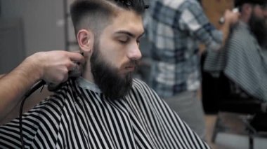 Erkek saç şekillendirme ile profesyonel düzeltici bir kuaför dükkanında yakından görmek. Kuaför Salonu Elektrik kesme makinesi ile kanununu mans. Saç bakım.