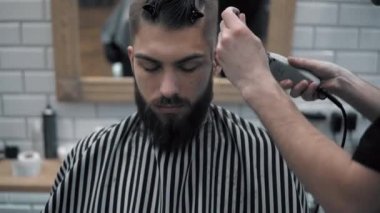 Erkek saç şekillendirme ile profesyonel düzeltici bir kuaför dükkanında yakından görmek. Kuaför Salonu Elektrik kesme makinesi ile kanununu mans. Saç bakım.