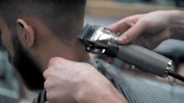 Erkek saç şekillendirme ile profesyonel düzeltici bir kuaför dükkanında yakından görmek. Kuaför Salonu Elektrik kesme makinesi ile kanununu mans. Saç bakım.