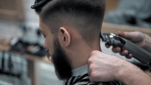 Närbild på hanar hårstyling i frisörsalong med professionella trimmer. Mans klippning på frisörsalong med elektrisk klippare. Grooming hår. — Stockvideo