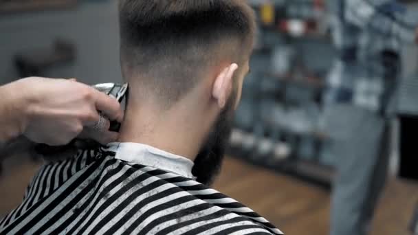 Vergrote weergave op mannetjes hairstyling in een kapper met professionele trimmer. Mans haircutting in kapsalon met elektrische clipper. Het verzorgen van het haar. — Stockvideo