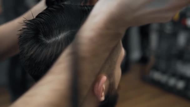 Close-up van Kapper doen styling met een knappe man met een lange baard. Kappers handen op werkproces. Kapper maken kapsel van aantrekkelijke bebaarde man in de kapsalon. Kapper op het werk. — Stockvideo