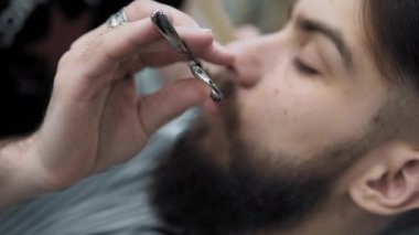 Yapıyor Kuaför saç kesimi ile yetişkin erkekler erkek kuaför salonu içinde uzun sakallı sakallar. Sakal bakım. Salonların işyerinde. Sakal saç şekillendirme ve kanununu bir kuaför dükkanında.