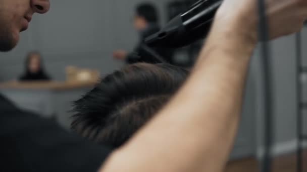 Close-up van Kapper doen styling met een knappe man met een lange baard. Kappers handen op werkproces. Kapper maken kapsel van aantrekkelijke bebaarde man in de kapsalon. Kapper op het werk. — Stockvideo