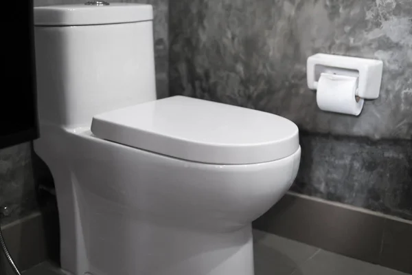 Asiento de inodoro colgante blanco en inodoro blanco en el baño de la casa con azulejos grises en estilo concreto y papel higiénico en la pared. Baño interior de lujo . — Foto de Stock