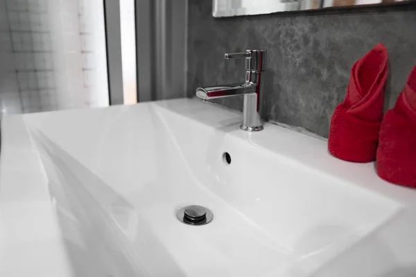 Moderní vodovod z nerezové oceli s umyvadlem umyvadla se dvěma červenými ručníky. Současný interiér koupelny. Přepychová a Stylová koupelna s betonovými zdmi stylu. — Stock fotografie