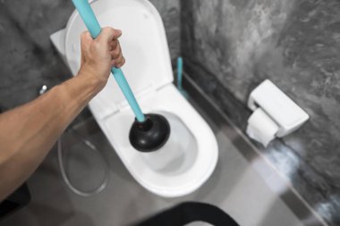 Tuvalet Pistonlu elle tuvalet tamiri. Sıhhi tesisat. Bir tesisatçı tuvaleti açmak için dalgıç kullanır. Tuvalet Piston.