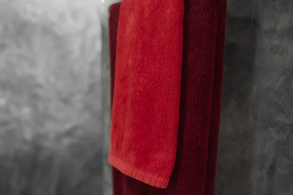 Una toalla roja en el baño en una secadora. Contador de baño interior contemporáneo. Lujo y elegante baño de diseño con paredes de hormigón . — Foto de Stock