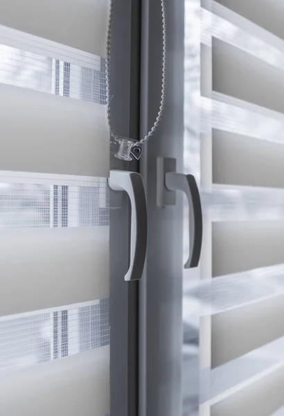 Window handle and white fabric roller blinds on the white plastic window in the living room. Close up on roll curtains indoor. — Stock Photo, Image